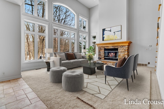 living room featuring plenty of natural light, a fireplace, baseboards, and tile patterned flooring