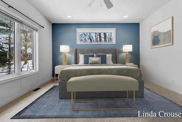 bedroom featuring carpet floors, a ceiling fan, visible vents, and multiple windows