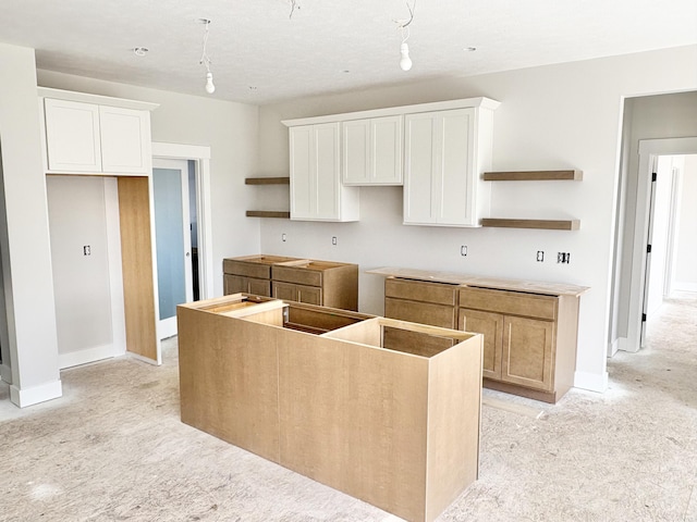 kitchen with white cabinets, a center island, and open shelves