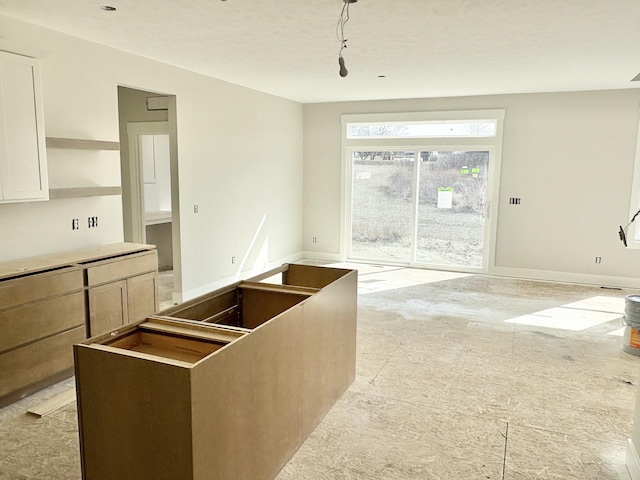 kitchen with open shelves, open floor plan, and baseboards