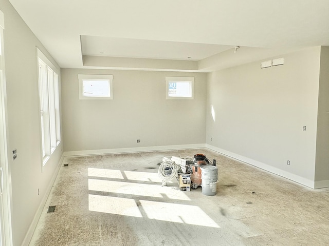 spare room with baseboards and a tray ceiling