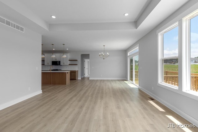 1798 Round Barn Dr, Hudsonville, MI 49426 - unfurnished living room with a chandelier, light wood-style floors, and recessed lighting