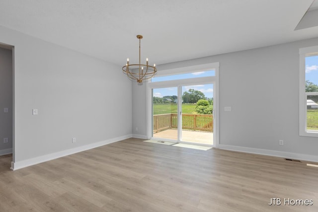 1798 Round Barn Dr, Hudsonville, MI 49426 - unfurnished dining area with a chandelier, healthy amount of natural light, and light wood-type flooring