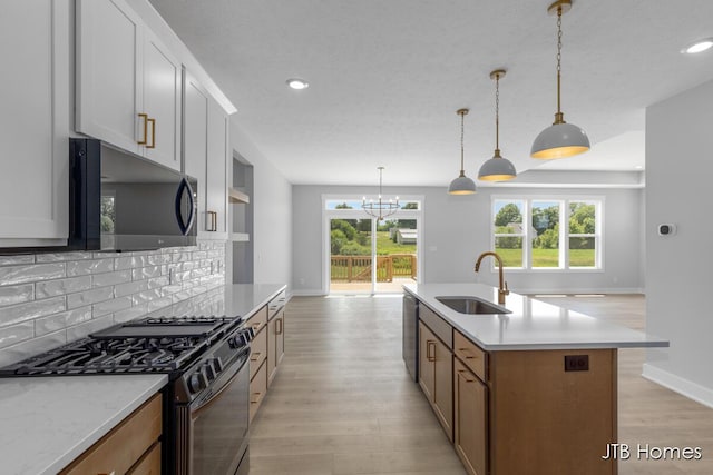 1798 Round Barn Dr, Hudsonville, MI 49426 - kitchen with range with gas stovetop, black microwave, plenty of natural light, light wood-style floors, and recessed lighting