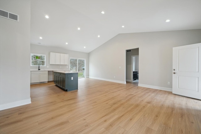 675 Crescent Lake Rd, Waterford, MI 48327 - kitchen with light wood finished floors, light countertops, an island with sink, white cabinetry, and open floor plan