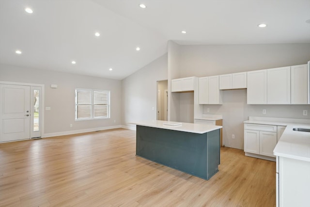 675 Crescent Lake Rd, Waterford, MI 48327 - kitchen with white cabinets, high vaulted ceiling, light wood-style flooring, recessed lighting, and a kitchen island