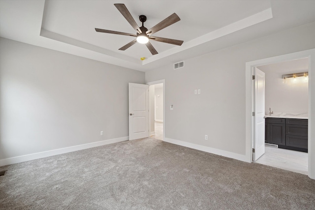 675 Crescent Lake Rd, Waterford, MI 48327 - unfurnished bedroom featuring light colored carpet, ensuite bath, baseboards, a tray ceiling, and visible vents