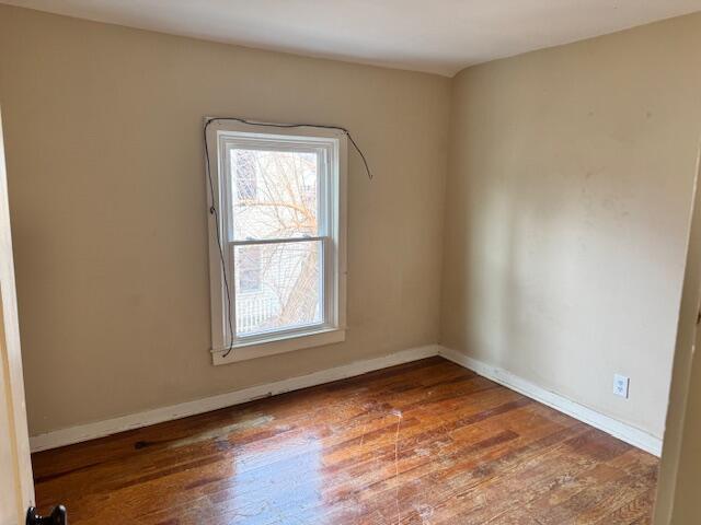 empty room with hardwood / wood-style flooring