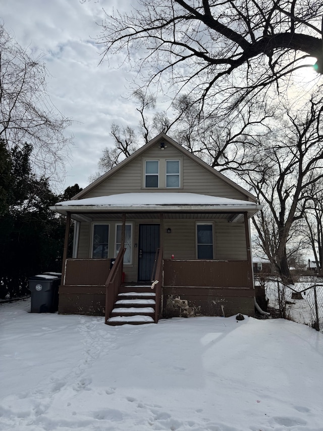 bungalow-style home with covered porch and fence