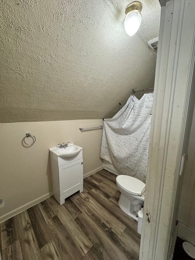 bathroom featuring a textured ceiling, toilet, and wood finished floors