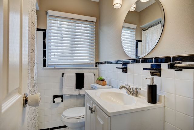 bathroom with vanity, tile walls, and toilet