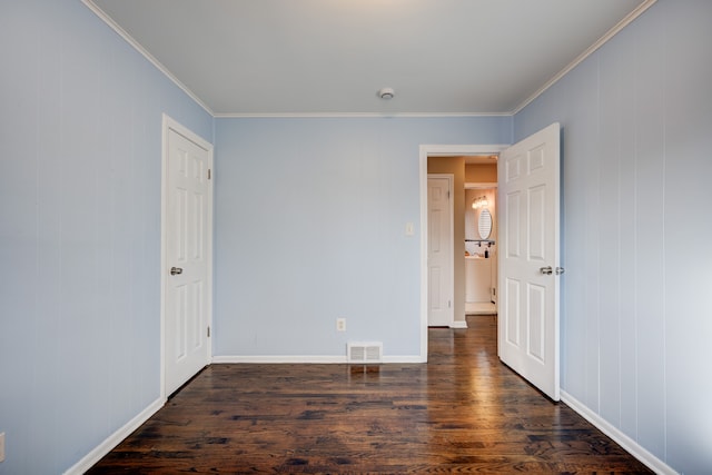 unfurnished bedroom with dark hardwood / wood-style flooring and crown molding