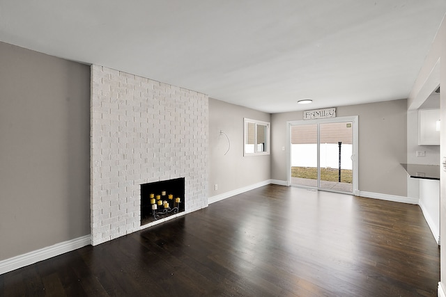 unfurnished living room with dark wood-style floors, a fireplace, and baseboards