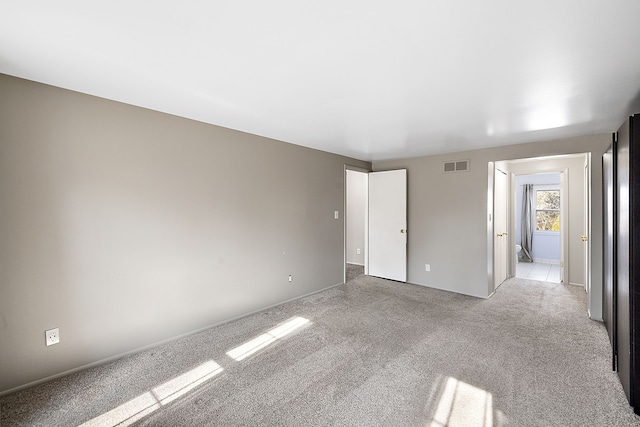 unfurnished bedroom featuring visible vents and light carpet