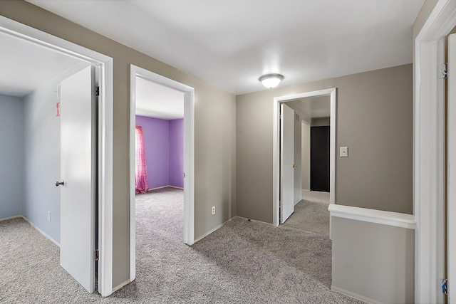 hallway with carpet flooring and baseboards