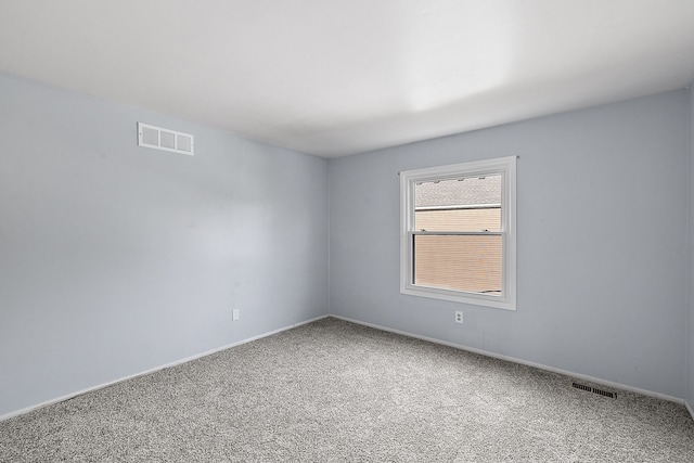 carpeted empty room featuring visible vents and baseboards