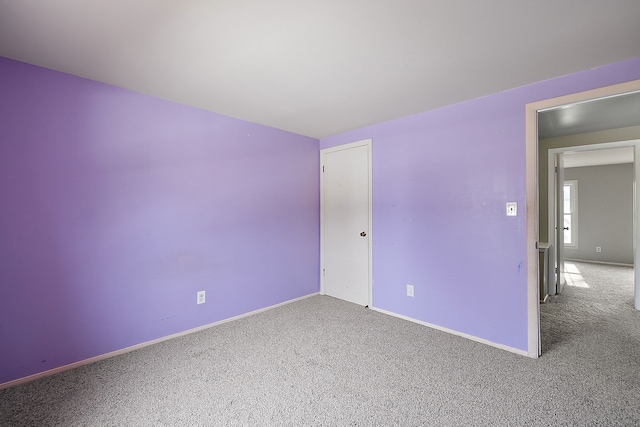 empty room featuring carpet flooring and baseboards