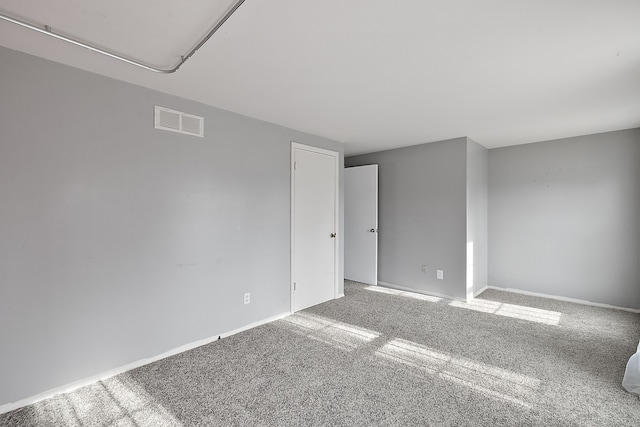 unfurnished room featuring carpet floors, baseboards, and visible vents