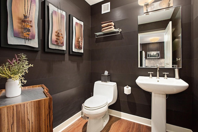 bathroom featuring hardwood / wood-style flooring and toilet