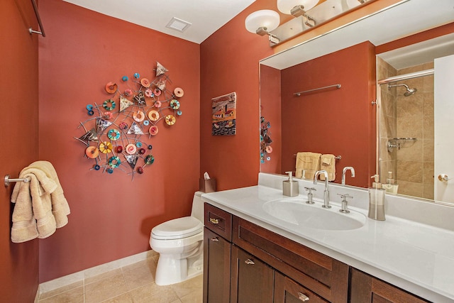 bathroom with vanity, a tile shower, tile patterned floors, and toilet