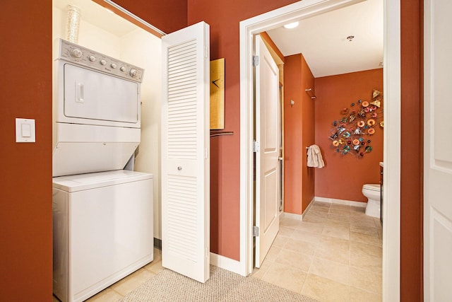 washroom with light tile patterned floors and stacked washer and clothes dryer