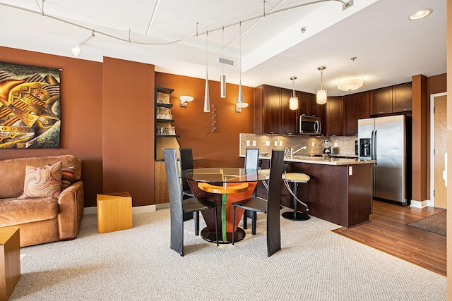 dining area with track lighting and light wood-type flooring