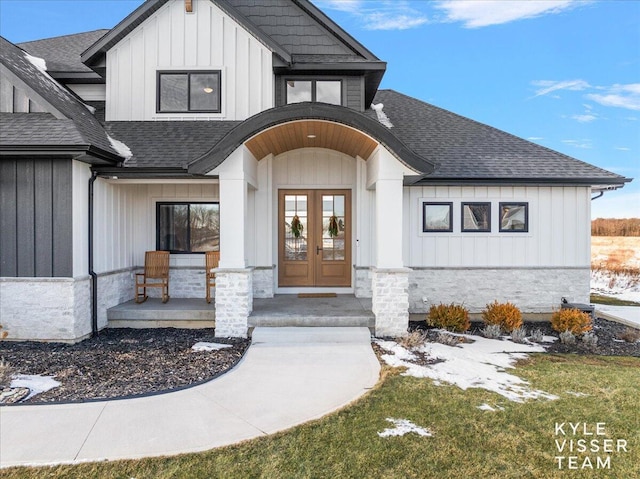 view of exterior entry with french doors and a porch