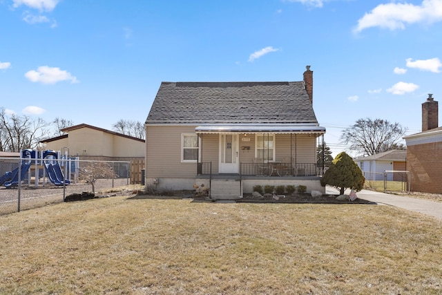 bungalow-style home featuring a porch, a playground, a front lawn, and fence