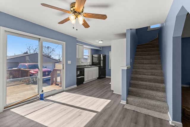 interior space with baseboards, wood finished floors, and a ceiling fan