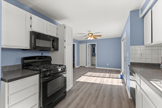 kitchen featuring black appliances, a ceiling fan, dark countertops, light wood-style floors, and decorative backsplash