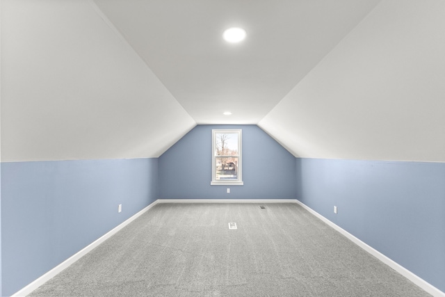 bonus room featuring lofted ceiling, carpet, and baseboards