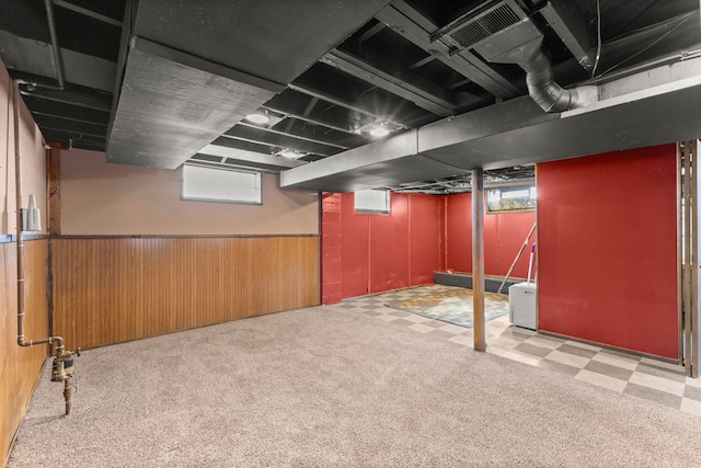 basement with tile patterned floors, wooden walls, carpet, and a wainscoted wall