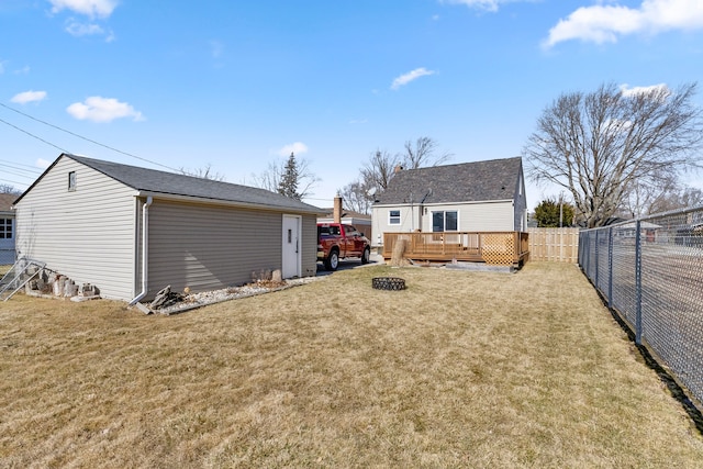 back of house featuring a deck, a lawn, and a fenced backyard