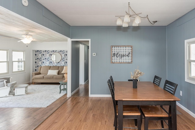 dining room featuring ceiling fan with notable chandelier and hardwood / wood-style floors