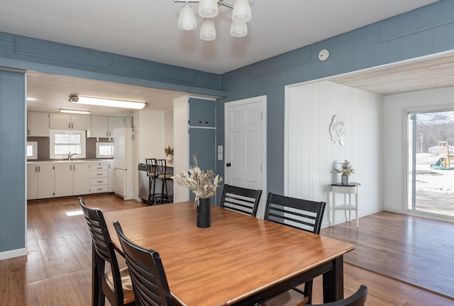 dining space featuring a healthy amount of sunlight, sink, and light hardwood / wood-style flooring