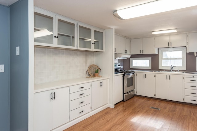 kitchen featuring white cabinetry, stainless steel electric range, light hardwood / wood-style floors, and decorative backsplash