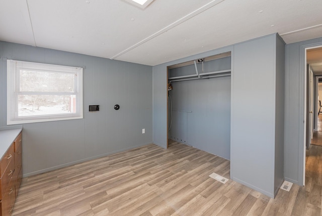 unfurnished bedroom with light hardwood / wood-style floors and a closet