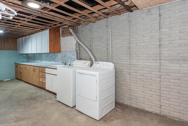 clothes washing area featuring cabinets, separate washer and dryer, and sink