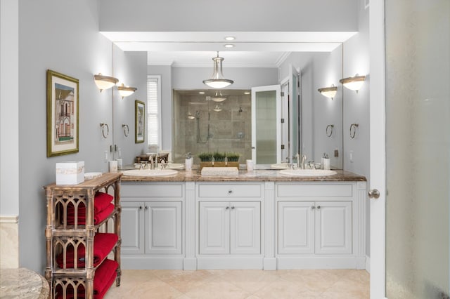 full bath featuring double vanity, a shower stall, ornamental molding, and a sink