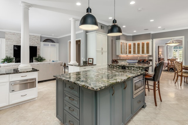 kitchen featuring a warming drawer, white cabinetry, ornate columns, and gray cabinets