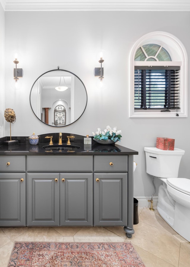 bathroom with vanity, baseboards, toilet, ornamental molding, and tile patterned flooring