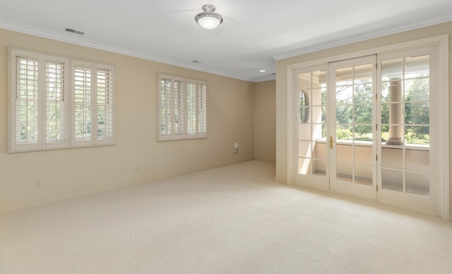 spare room featuring visible vents, carpet flooring, a wealth of natural light, and ornamental molding