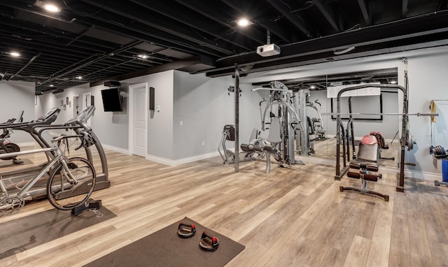 exercise area featuring baseboards and wood finished floors