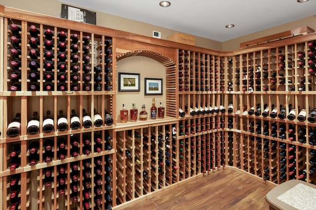 wine room with recessed lighting, wood finished floors, and visible vents