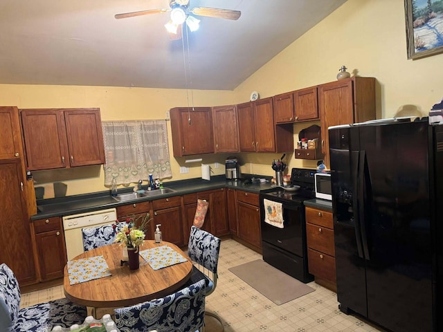 kitchen featuring lofted ceiling, light floors, a sink, black appliances, and dark countertops