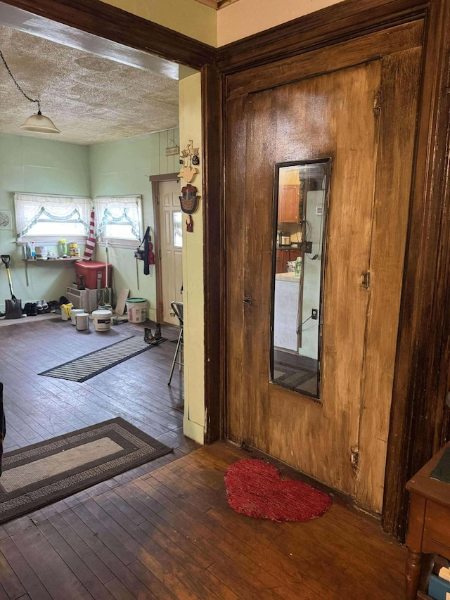 hall featuring a textured ceiling and hardwood / wood-style floors