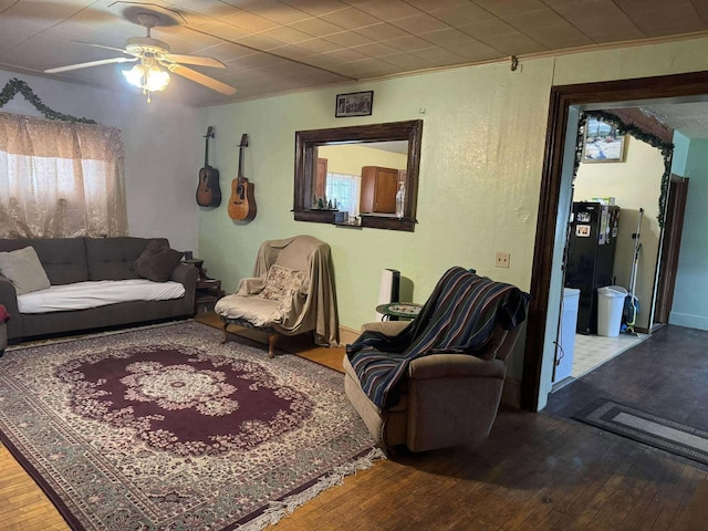 living area with a ceiling fan, crown molding, and hardwood / wood-style flooring