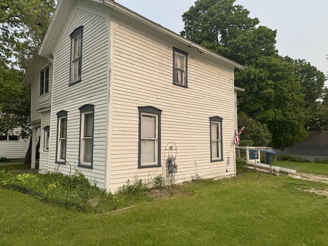 313 W 6th St, Evart, MI 49631 - view of side of home featuring a lawn