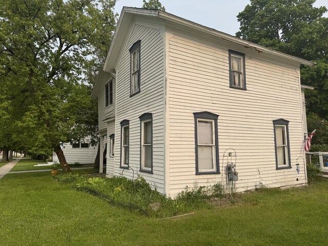 313 W 6th St, Evart, MI 49631 - view of home's exterior featuring a yard