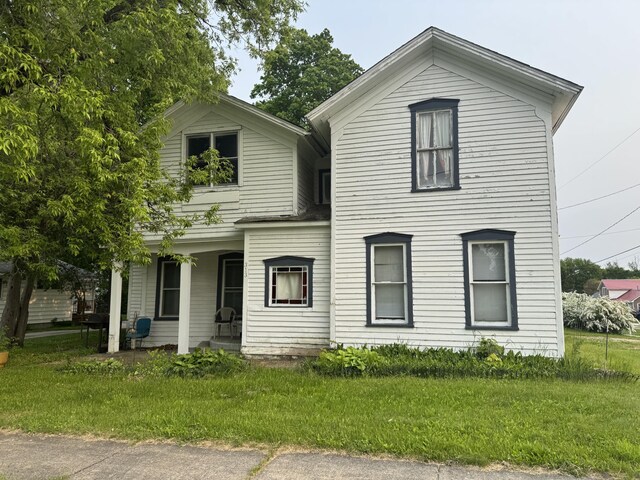 313 W 6th St, Evart, MI 49631 - view of front of property with a porch and a front yard
